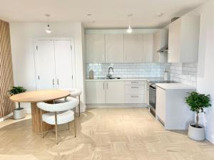 a kitchen with a wooden table and white cabinets at Short term apartment in London in London