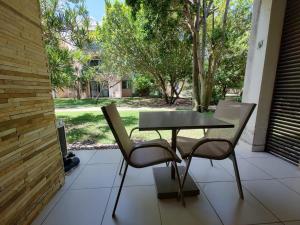 バーハ・デ・サン・ミゲウにあるFlat no loa Resort & Residenceのパティオ(テーブル、椅子付)