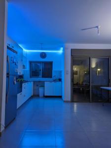 une cuisine avec une lumière bleue dans une pièce dans l'établissement Private room in shared Apartment, à Jérusalem