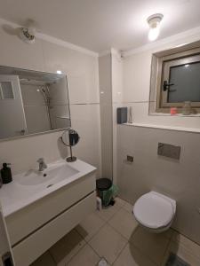 a bathroom with a white sink and a toilet at Private room in shared Apartment in Jerusalem