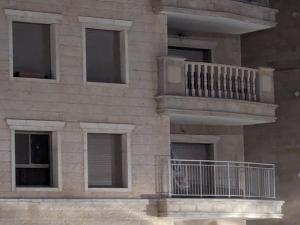 - un bâtiment en briques avec des fenêtres et un balcon dans l'établissement Private room in shared Apartment, à Jérusalem
