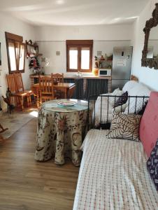a room with two beds and a table and a kitchen at Cortijo Las Pilares in Granada
