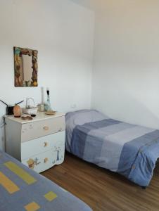 a bedroom with two beds and a dresser and a mirror at Cortijo Las Pilares in Granada