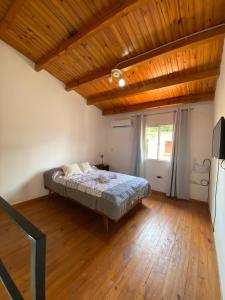 1 dormitorio con cama y techo de madera en Temporario hospital en Posadas