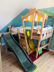 um quarto para crianças com um beliche e um escorrega em Maison familiale proche plage em Lorient