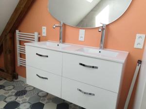 uma casa de banho com 2 lavatórios e um espelho em Maison familiale proche plage em Lorient