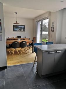 uma cozinha e sala de jantar com mesa e cadeiras em Maison familiale proche plage em Lorient