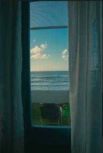 a view of the ocean from a window at Casa Prema - Experiência vegana e terapêutica à beira-mar in Maceió