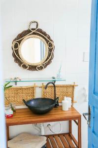 uma casa de banho com um lavatório preto e um espelho em Casa Prema - Experiência vegana e terapêutica à beira-mar em Maceió
