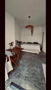 ein Schlafzimmer mit einem Bett und einem Tisch darin in der Unterkunft Casa Prema - Experiência vegana e terapêutica à beira-mar in Maceió