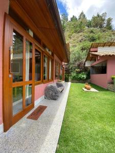 - une vue sur l'extérieur d'une maison avec une pelouse dans l'établissement Pousada Aracê, à Pedra Azul
