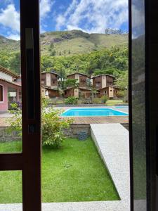 a view from the door of a house with a swimming pool at Pousada Aracê in Pedra Azul