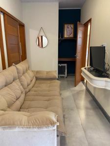 - un salon avec un canapé et une télévision dans l'établissement Pousada Aracê, à Pedra Azul