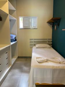 a small bedroom with a bed and a window at Pousada Aracê in Pedra Azul
