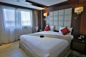 a hotel room with a large white bed with red pillows at EGYPT NILE CRUISE in Aswan