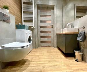 a bathroom with a toilet and a sink at Apartament Rejs in Ostróda
