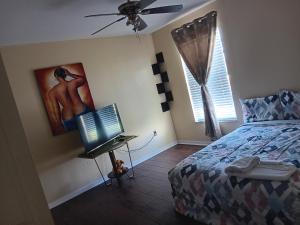 a bedroom with a bed and a computer on a desk at Pinecone Park in Wimauma