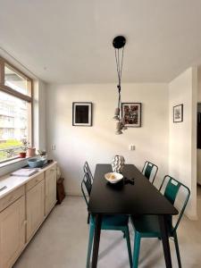 une salle à manger avec une table et des chaises noires dans l'établissement Lovely, light and calm 1-bedroom apartment, à Amsterdam
