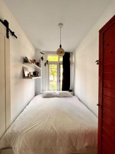 a bedroom with a large bed with a window at Lovely, light and calm 1-bedroom apartment in Amsterdam