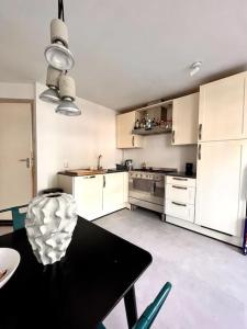 cocina con mesa negra y armarios blancos en Lovely, light and calm 1-bedroom apartment en Ámsterdam