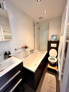 a bathroom with a sink and a toilet and a tub at Lovely, light and calm 1-bedroom apartment in Amsterdam