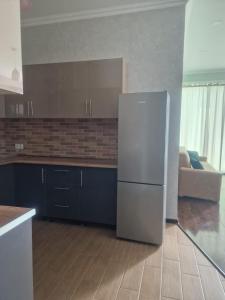 a kitchen with a refrigerator and a couch at vekuas apartments in Tbilisi City