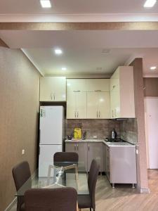 a kitchen with a table and a white refrigerator at vekuas apartments in Tbilisi City