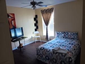 a bedroom with a bed and a flat screen tv at Pinecone Park in Wimauma