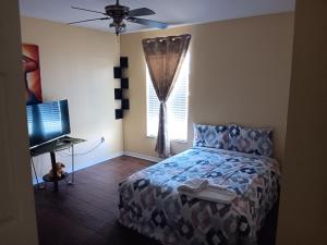 a bedroom with a bed and a computer and a window at Pinecone Park in Wimauma