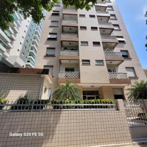 a tall apartment building with a balcony at Apto no Embaré pé na areia in Santos