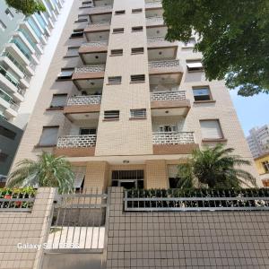 a tall building with palm trees in front of it at Apto no Embaré pé na areia in Santos +26 photos