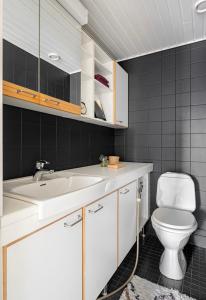 a bathroom with a white sink and a toilet at Bright and spacious condo near subway with FREE parking in Espoo
