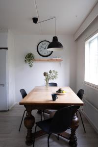 a dining room table with chairs and a clock on the wall at Bright and spacious condo near subway with FREE parking in Espoo