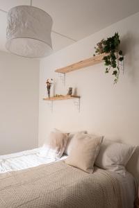 1 dormitorio con 1 cama y una maceta en la pared en Bright and spacious condo near subway with FREE parking, en Espoo