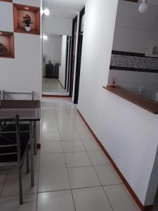 korytarz z białymi ścianami, stołem i krzesłami w obiekcie Apartamento en Villavicencio w mieście Villavicencio