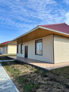 a small white building with a red roof at Домик у реки 