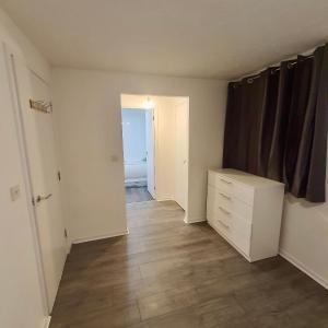 an empty room with a dresser and a bedroom at Comfortable and Cosy London Stay in London