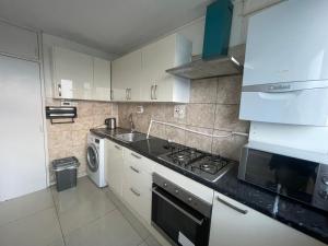 a kitchen with a stove top oven next to a microwave at Norland House in London