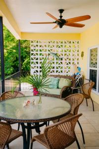 a patio with a table and chairs and a ceiling fan at Fiesta in Enighed