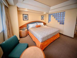 um quarto de hotel com uma cama e duas cadeiras em Hotel Torremolinos Vallejo Ciudad de Mexico em Cidade do México