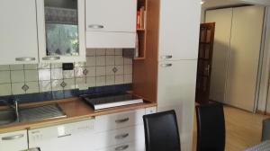 una cocina con armarios blancos y fregadero en Appartamento Modena Park, en Módena
