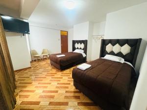 a bedroom with two beds and a wooden floor at HOTEL ROYAL INCA INN in Cusco