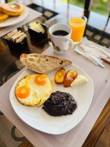 a plate with eggs and bread and a cup of coffee at Hotel Quinta Vista Verde in Antigua Guatemala