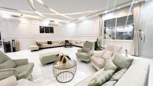 ein großes Wohnzimmer mit Sofas und einem Tisch in der Unterkunft شالية ديور الفندقي in Al Wudayy