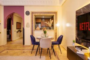 Appartement Haut Standing Gueliz Plaza avec Vue في مراكش: غرفة طعام مع طاولة وكراسي