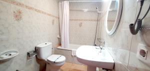 Baño blanco con aseo y lavamanos en Sidreria La Casa Abajo en La Franca