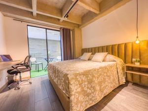 Schlafzimmer mit einem Bett, einem Schreibtisch und einem Fenster in der Unterkunft B 48 Living by B Rent in Medellín