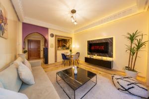 sala de estar con sofá y TV en Appartement Haut Standing Gueliz Plaza avec Vue en Marrakech