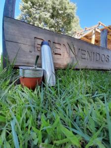 a thermos sitting in the grass in front of a sign at Cabaña Don floricel in Santa Ana
