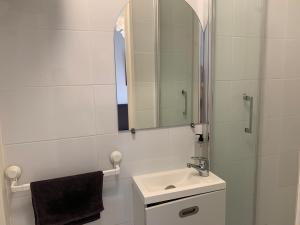 a white bathroom with a sink and a mirror at Appartement moderne metro 9 in Boulogne-Billancourt
